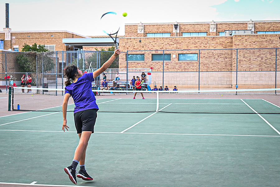A girl hits the tennis ball back to her opponent