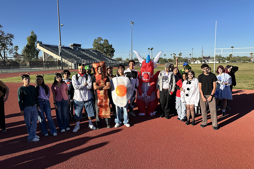 A group of students dressed up in costumes stand on the track
