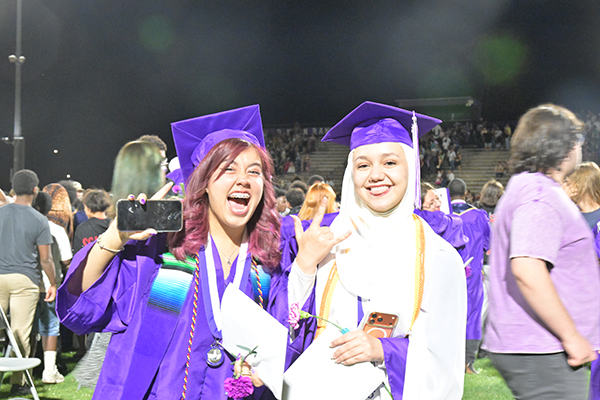 Two teen girls smile during their graduation