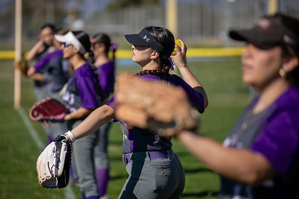 A row of girls warming up for the softball game