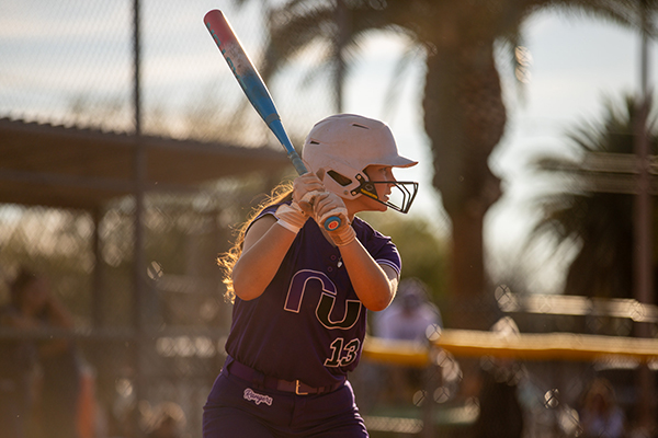 A girl prepares to hit the softball with her bat