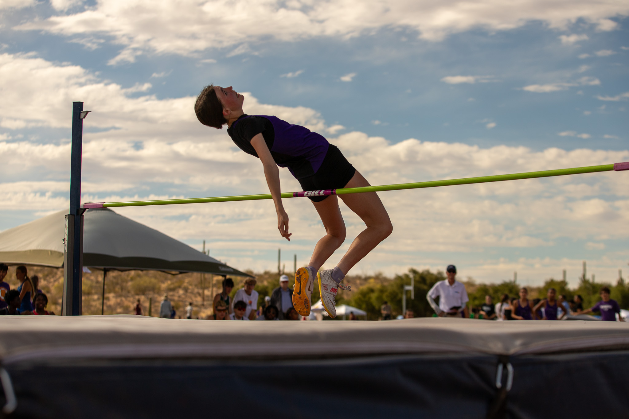 A girl jumps backwards over the high jump