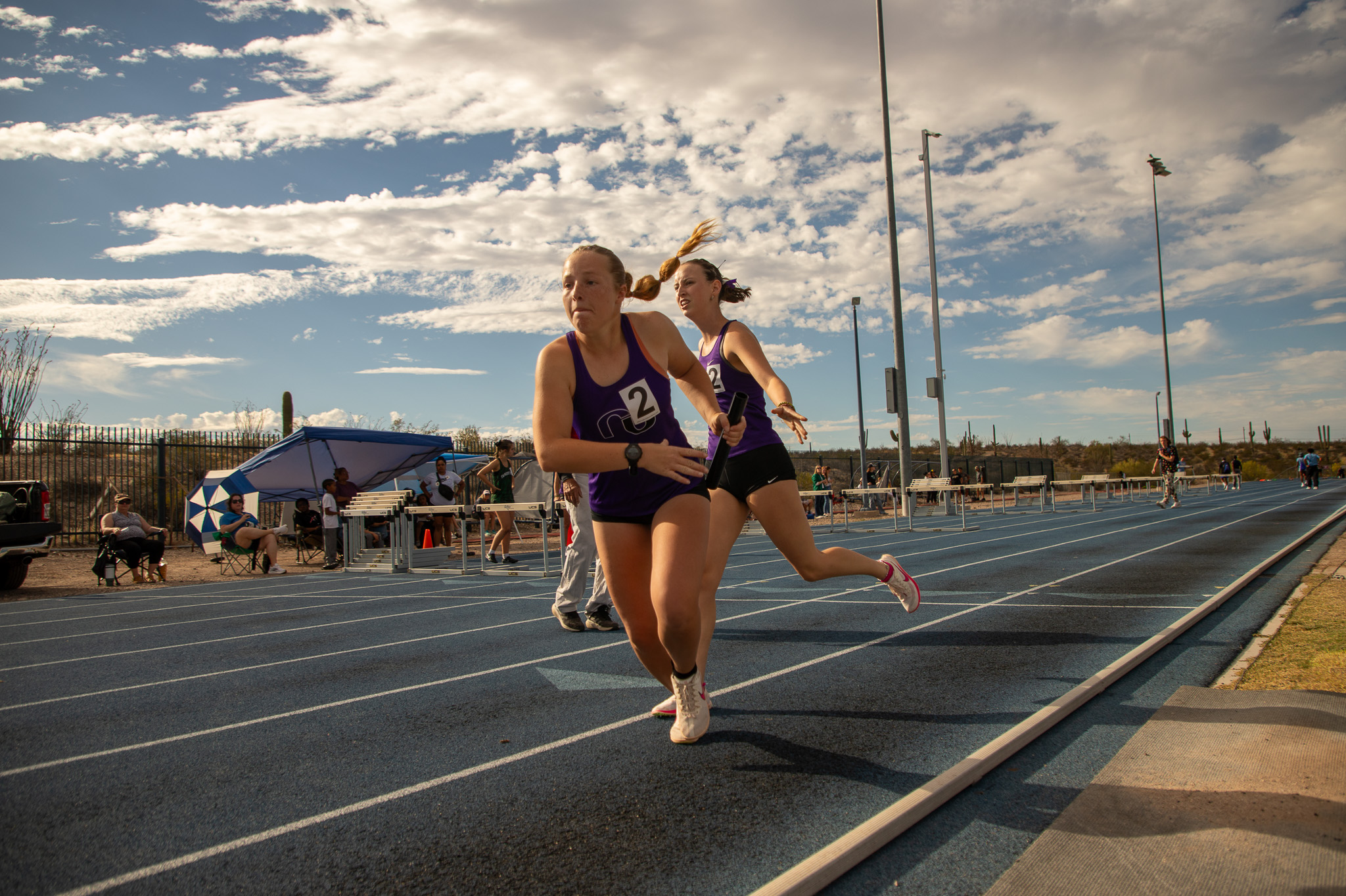 Two girls exchange the baton during the track meet